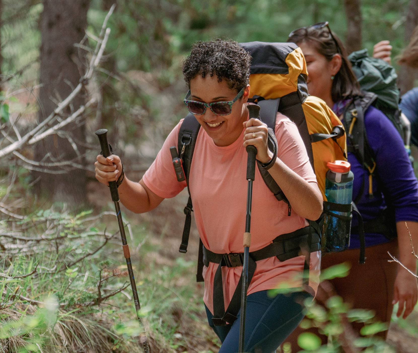 Group of hikers on a forest trail, the nearest carrying a GoBottle