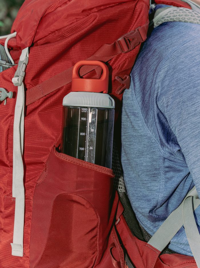GoBottle carried upright in the side pocket of a red hiking pack