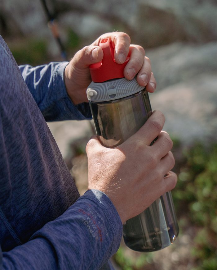 Close-up of two hands opening the twist lid of a GoBottle